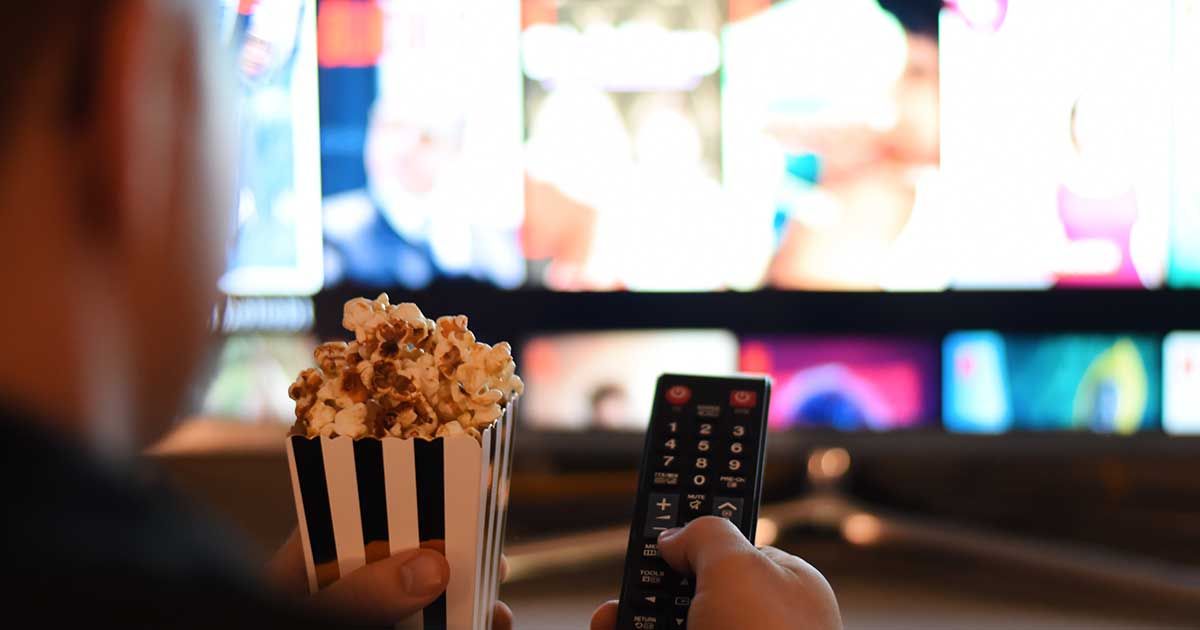 Man Holding Remote and Popcorn