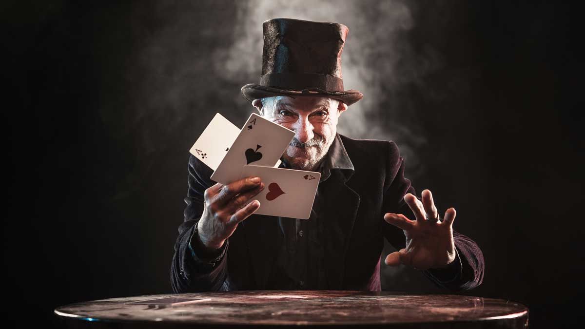 Magician holding the Ace of Spades, Hearts and Clubs