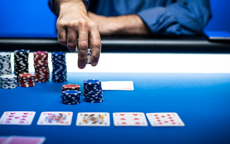 Man Betting Chips At Poker Table